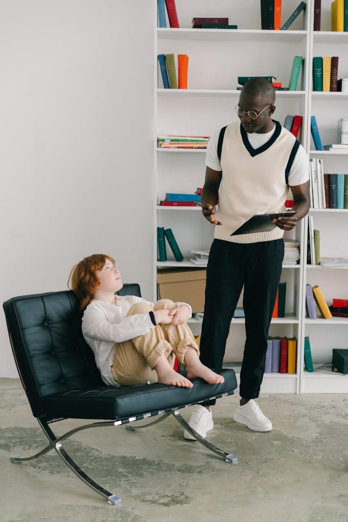 A Boy in White Long Sleeves Sitting on a Chair